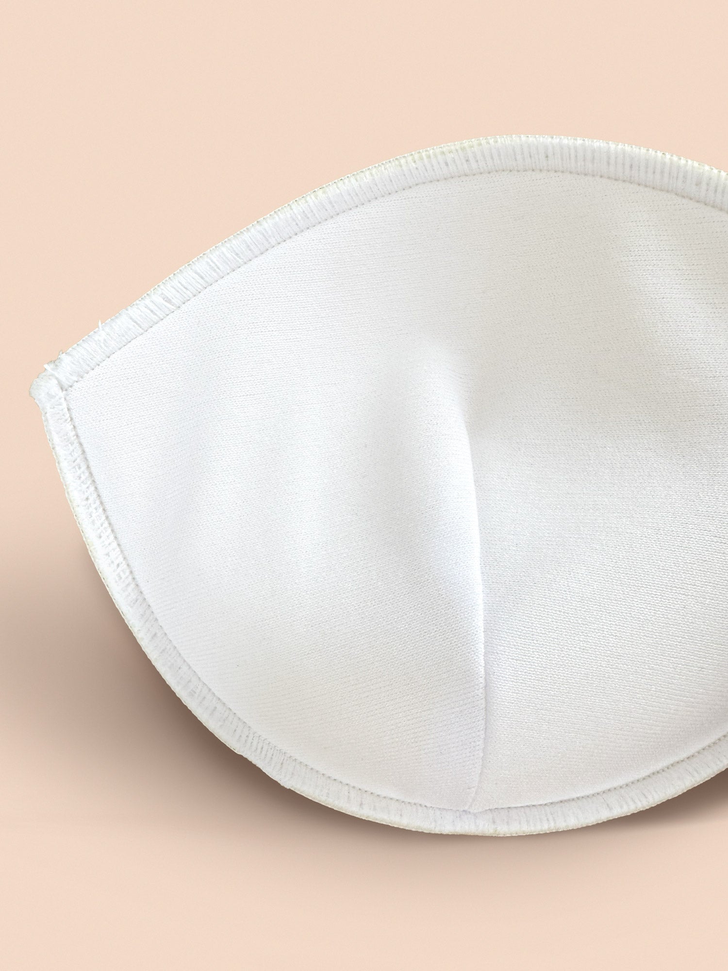 Close-up of interior pad side of 2 inch thick bra inserts in foam.