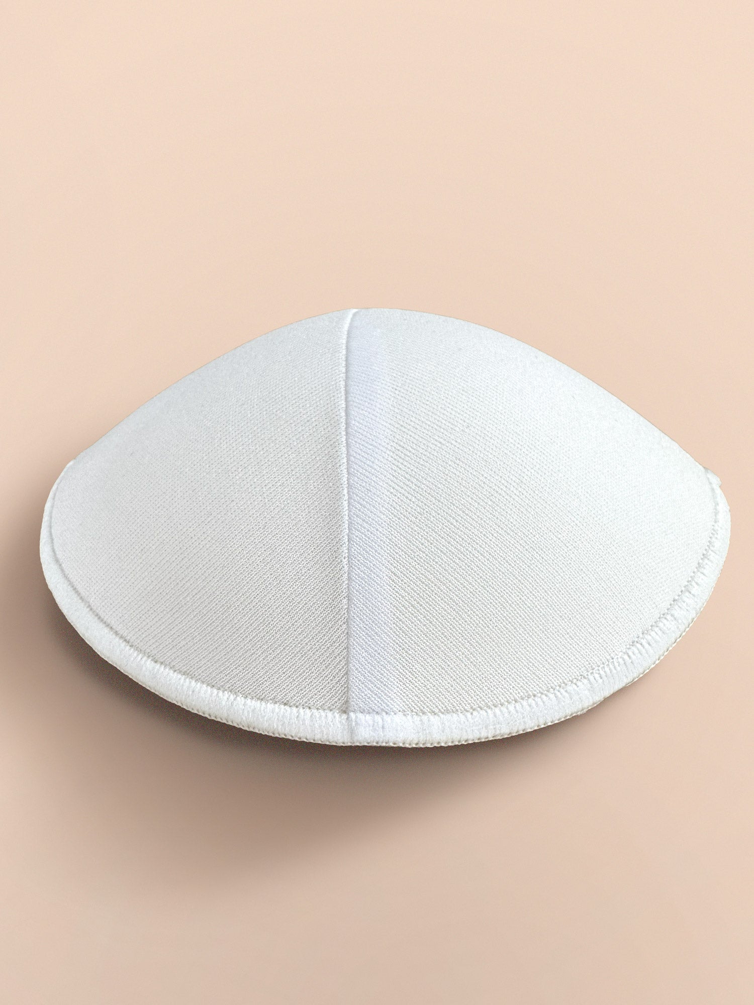 Profile view of white cloth lined Bra inserts for bras, sports bras and swimsuit pockets.