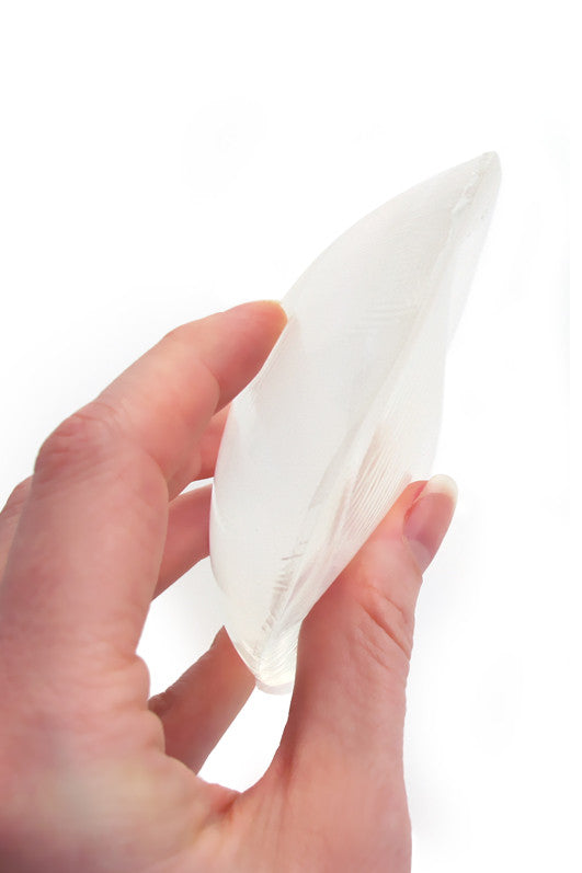 Hand holding Boobles - Full-cup Clear Round Silicone Bra Inserts for added curves and support.